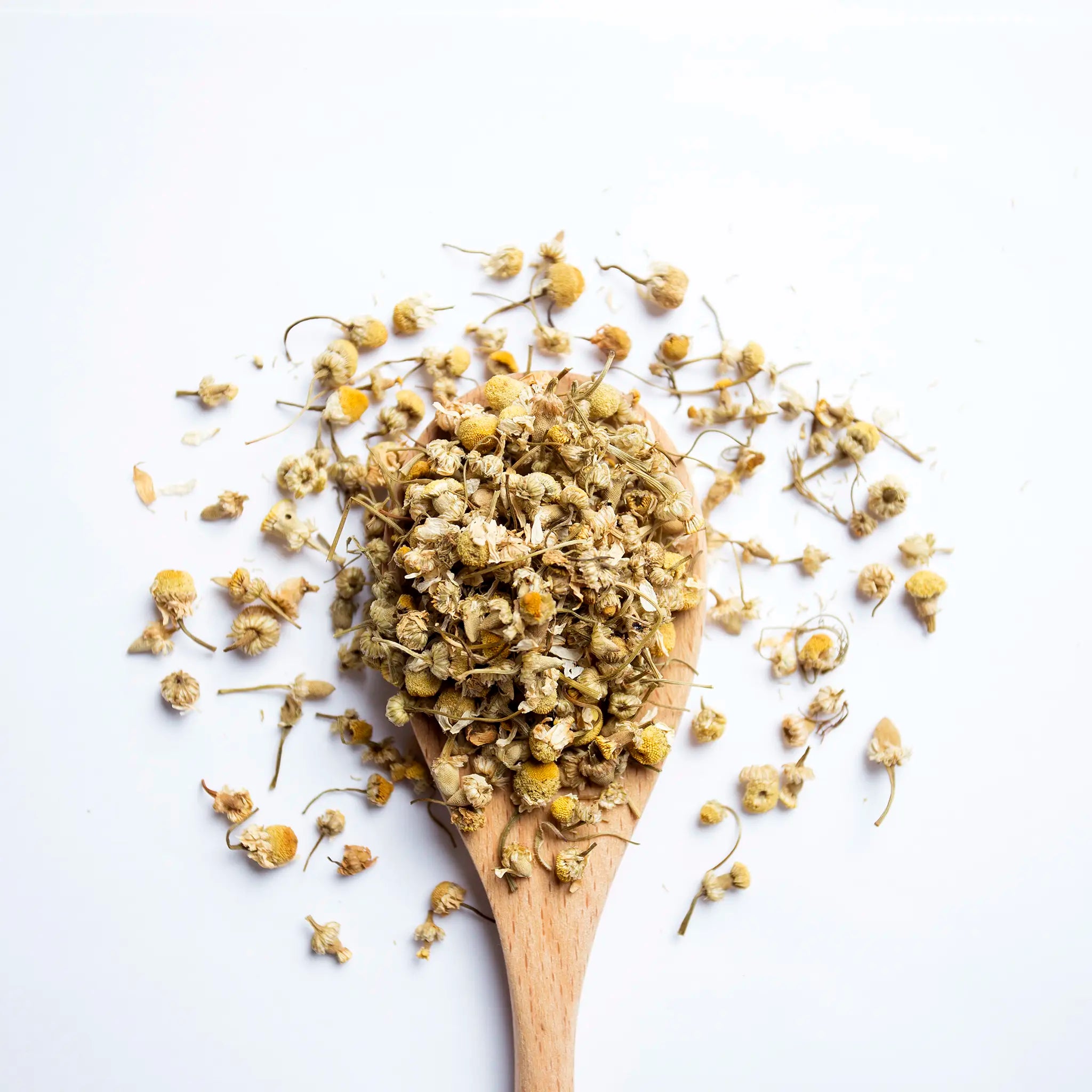 A wooden spoon with loose leaf tea