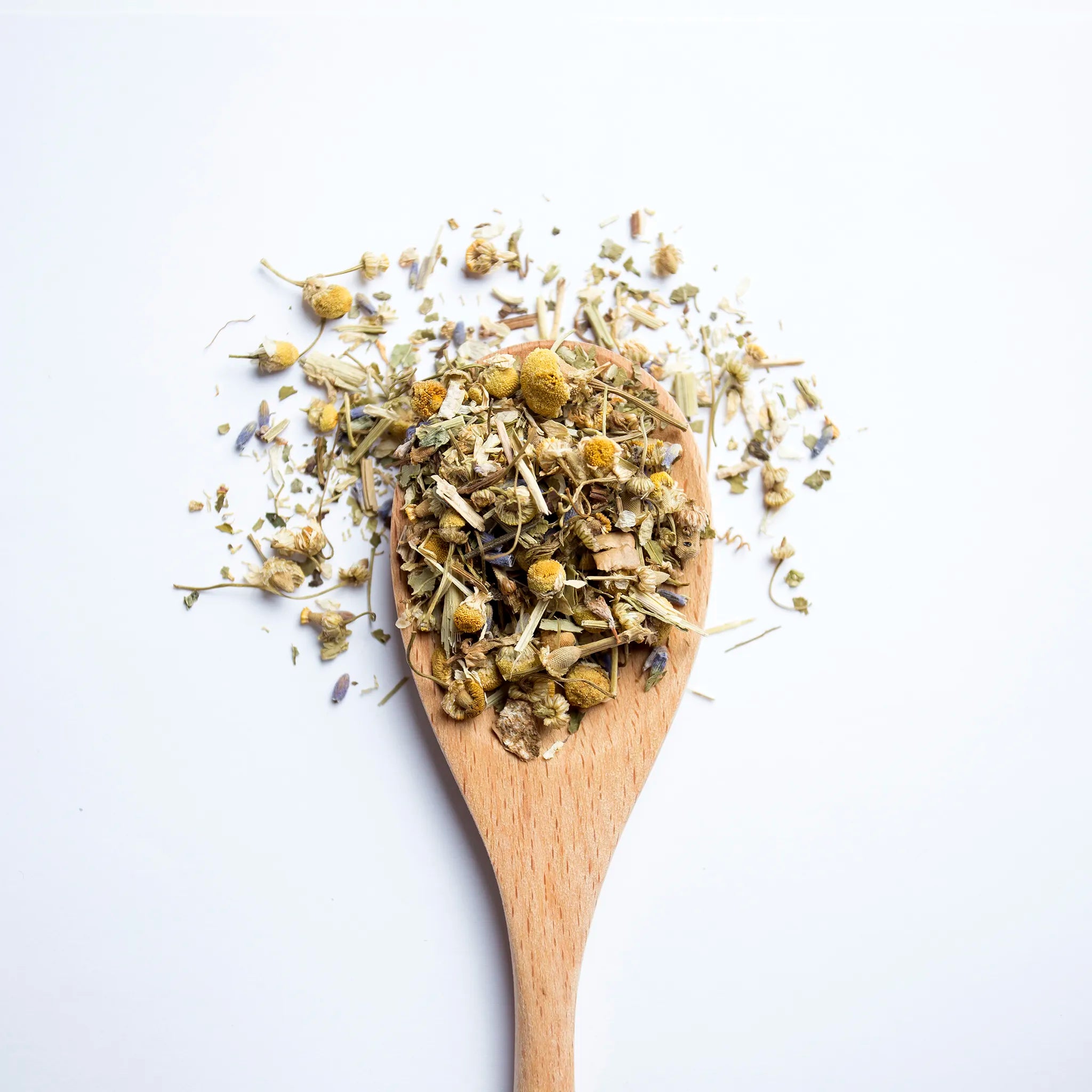 A wooden spoon with loose leaf tea