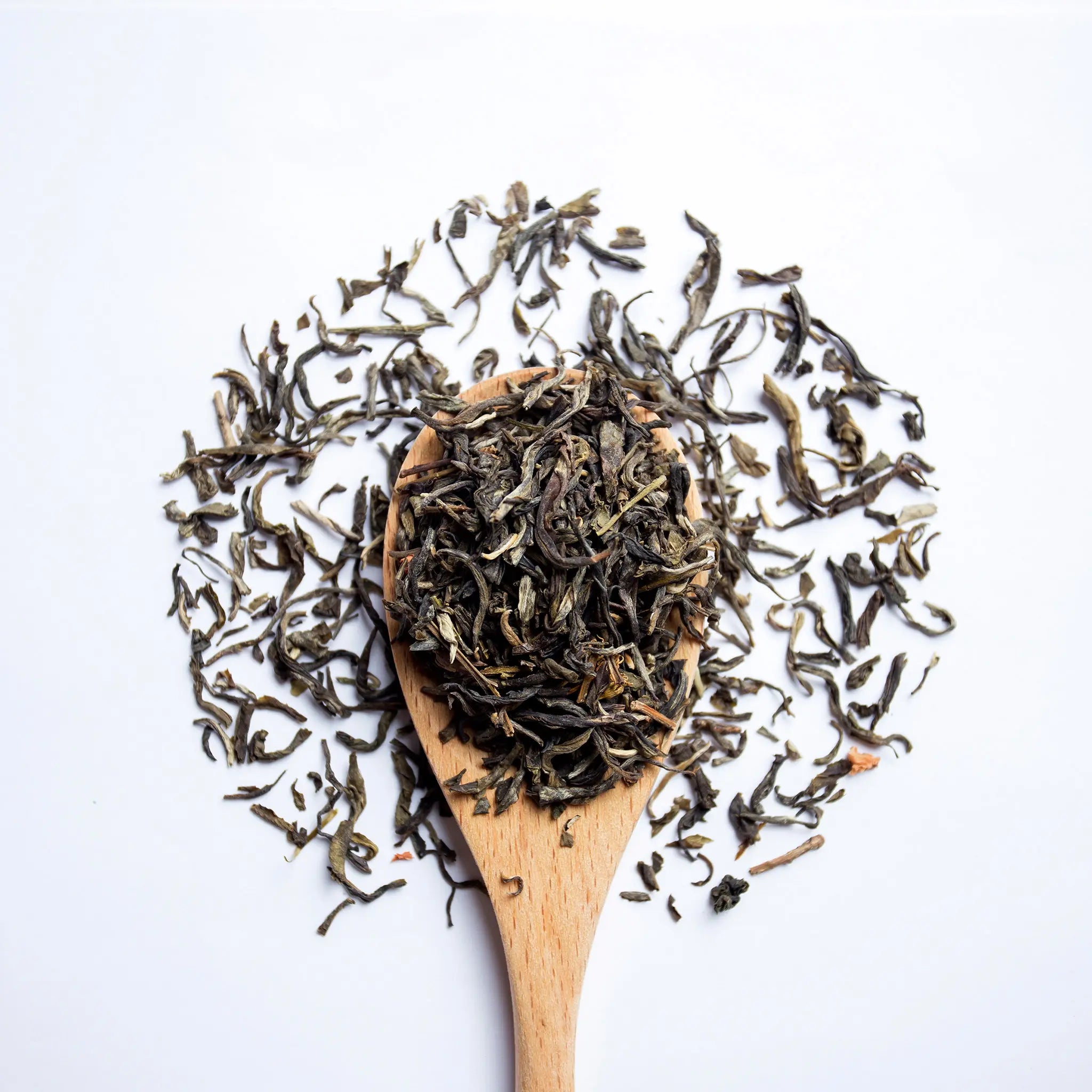 A wooden spoon with loose leaf tea